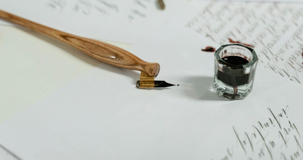 A graceful still life of handwritten calligraphy with a quill pen and ink on paper, showcasing artistic elegance.